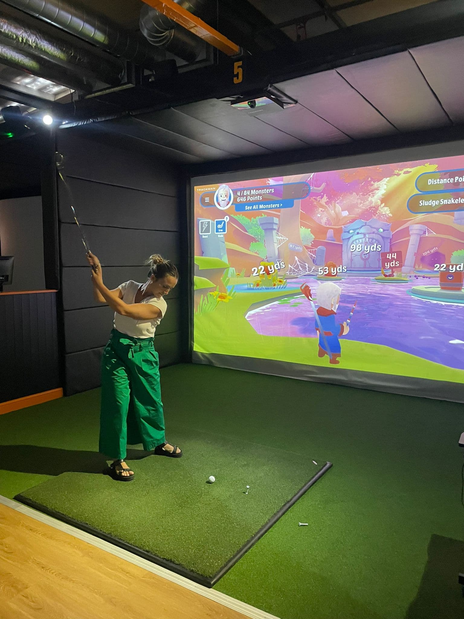 Guest teeing off in Enzo Golf TrackMan iO simulator bay